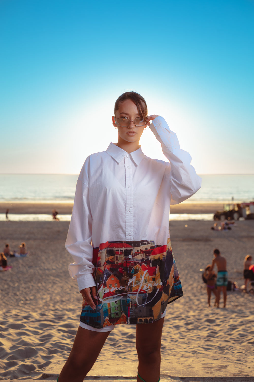 Model on the beach at sunset wearing the white 'Handelskade' shirt