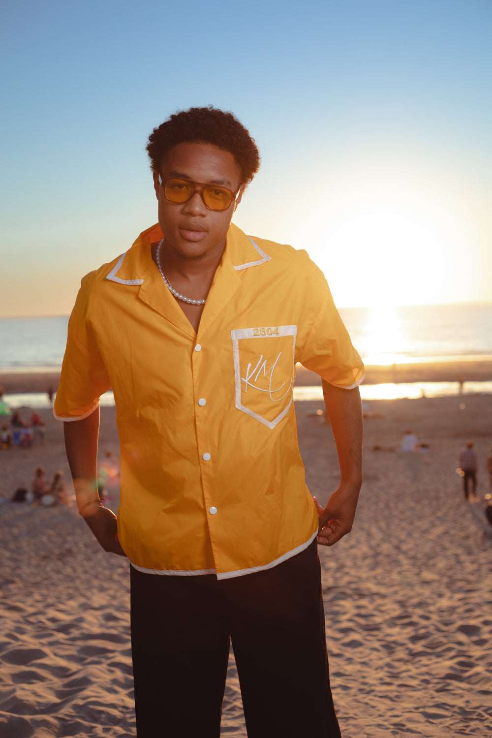 Model on the beach at sunset in the yellow 'Penha' shirt